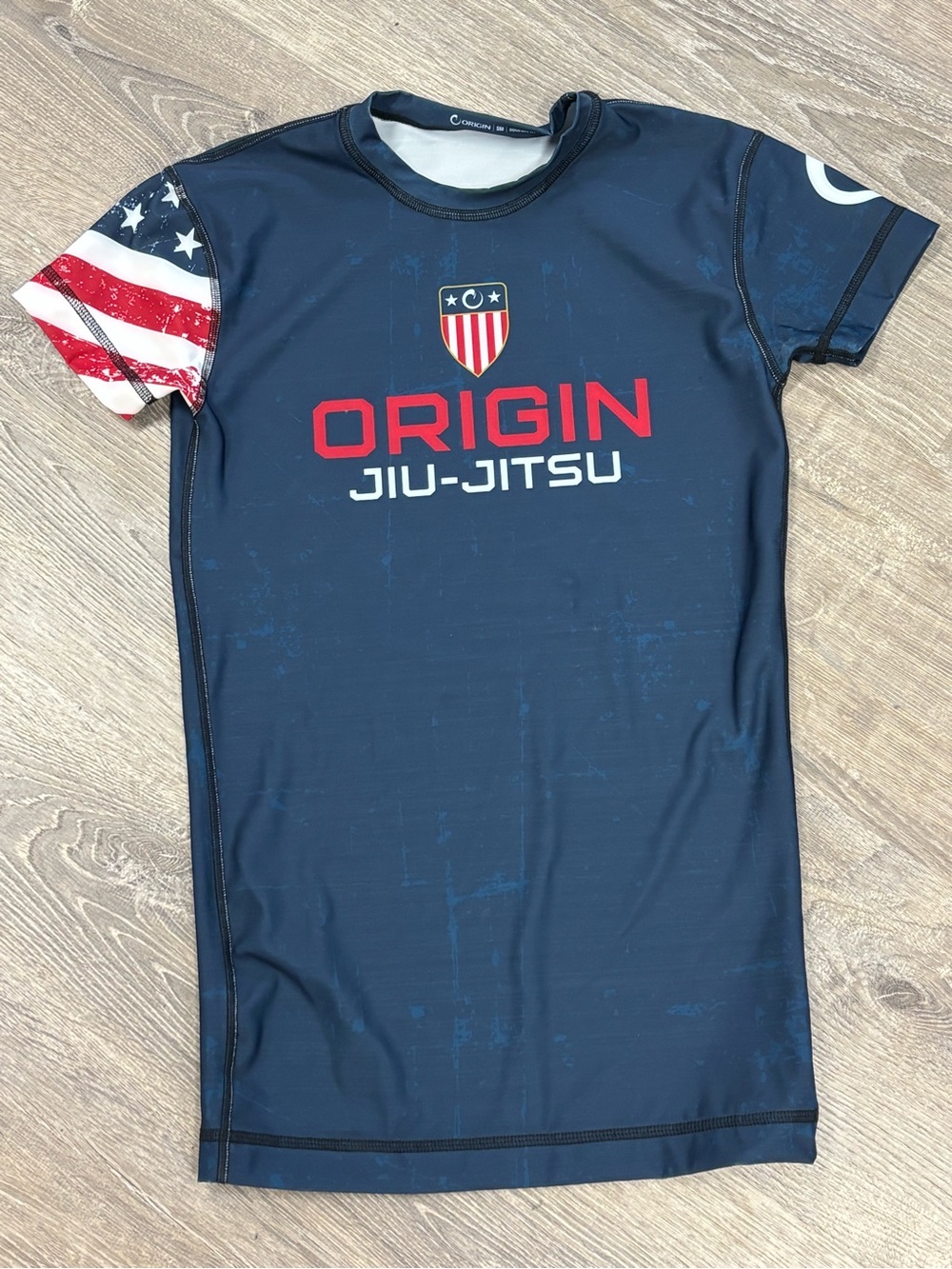 Origins Navy Performance Rash Guard with Red, White and Gold Shield